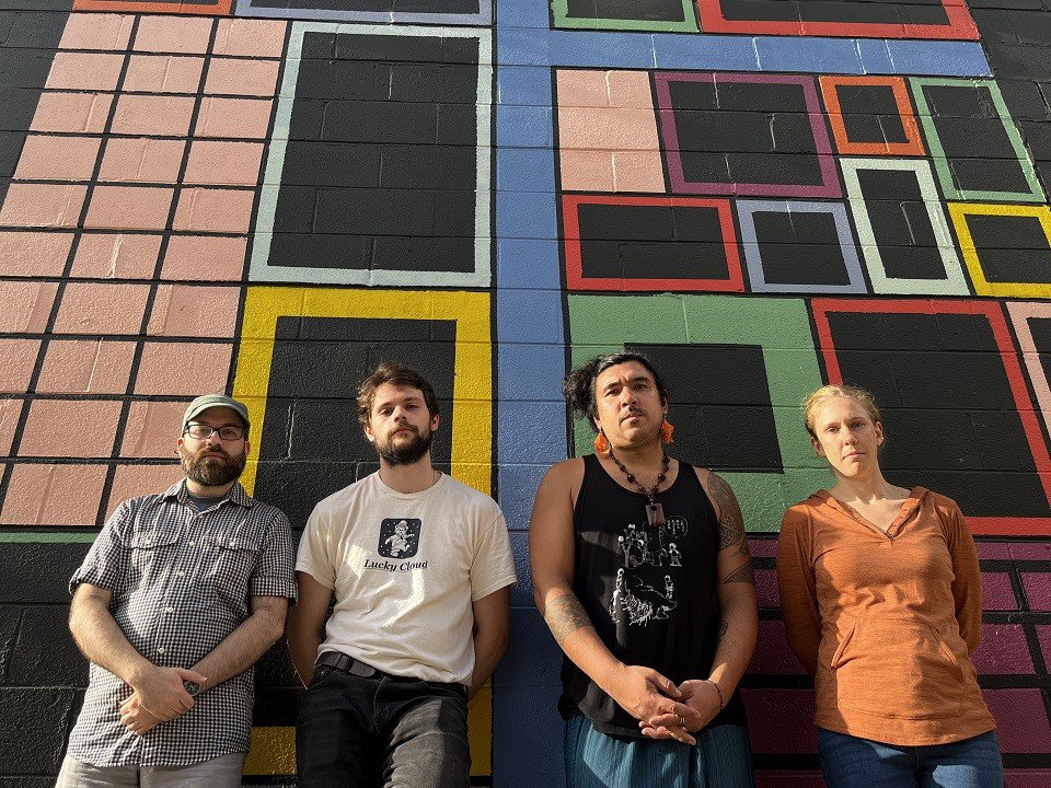 Jakob Heinemann Quartet in front of a mural.