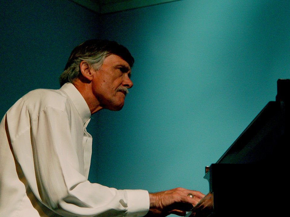 John Harmon at a piano.