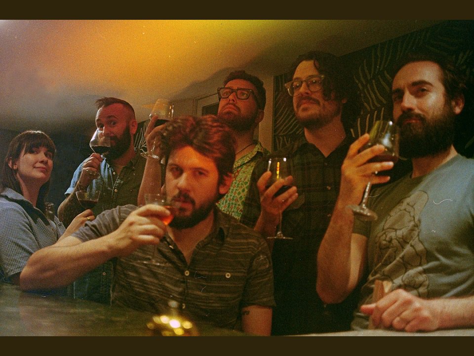 The six-piece band Marigold Motel pauses for a drink.