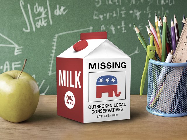 A milk carton on a teacher's desk with an image on it that says "Missing: outspoken local conservatives."