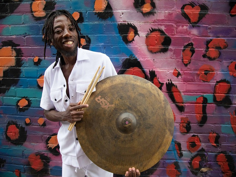Paa Kow, a cymbal and drumsticks.