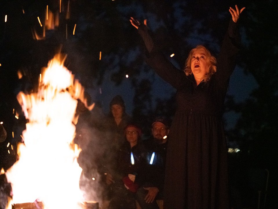 A singer by a roaring fire.