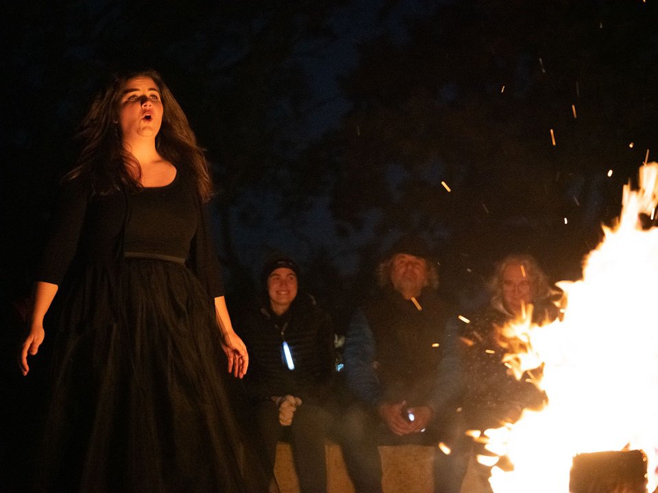 A singer by a roaring fire.