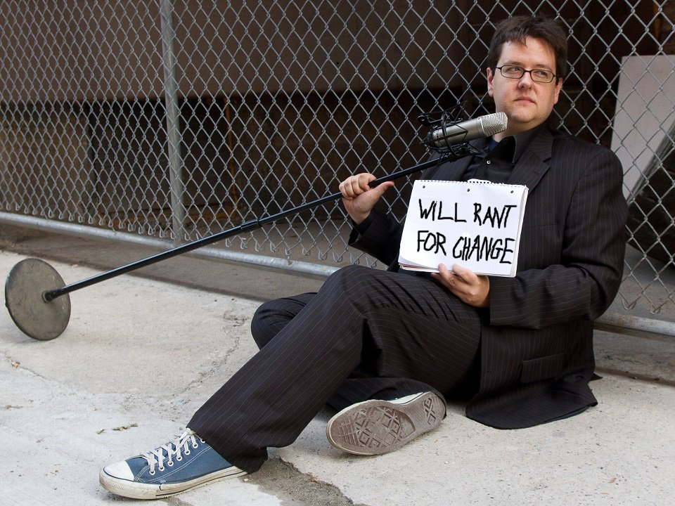 Matthew Filipowicz and a mic stand, sitting on a sidewalk.