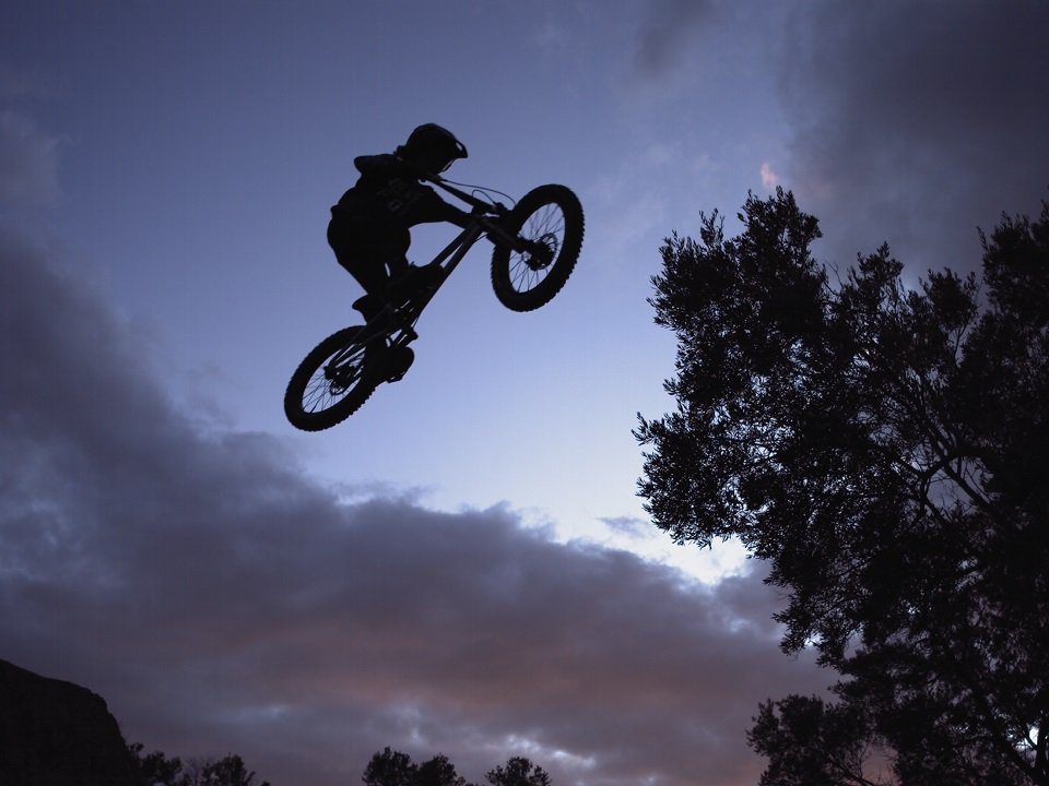 A bicyclist silhouetted against a dusk sky.