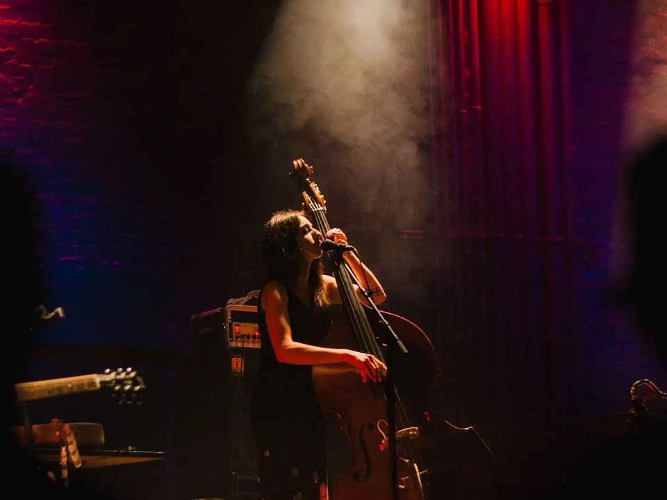 Mali Obomsawin of Deerlady and bass on stage.