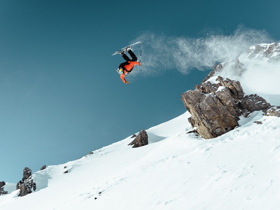 A snowboarder far above the slopes.