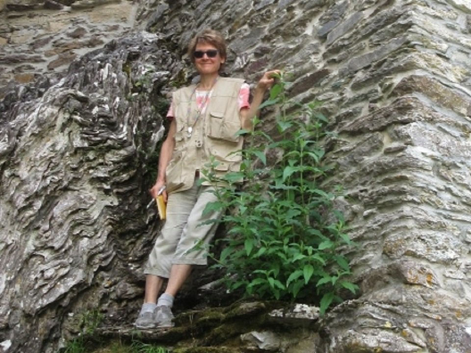 Marcia Bjornerud standing by a rock wall.