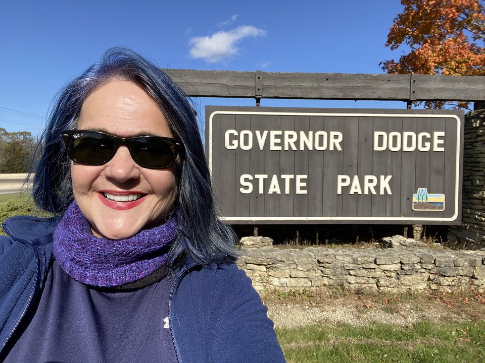 Betsy Korbinyr in front of a state park sign.