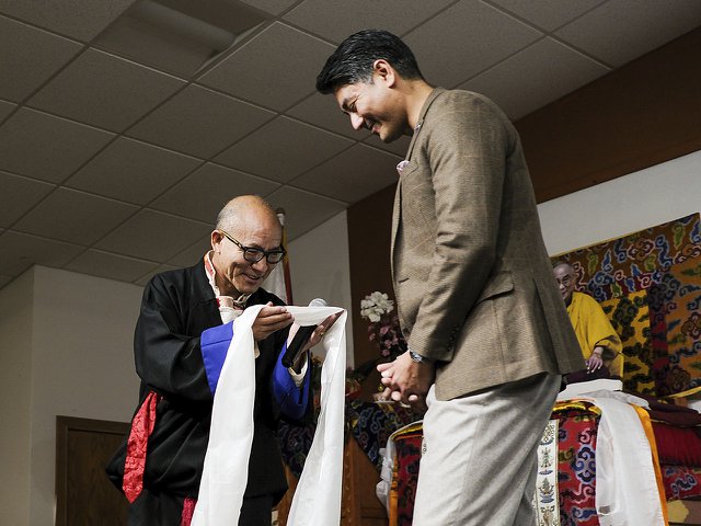 Chikyap Dhonpa, president of the Wisconsin Tibetan Association, left, presents Cincinnati Mayor Aftab Pureval with a ceremonial scarf, a symbol of honor and respect.