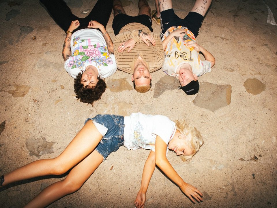 Amyl and the Sniffers lying on a cement floor.