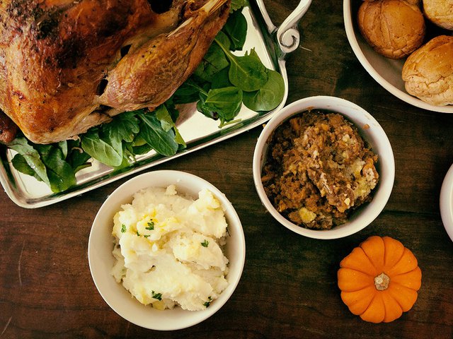 A roast turkey, mashed potatoes, stuffing and a mini pumpkin.