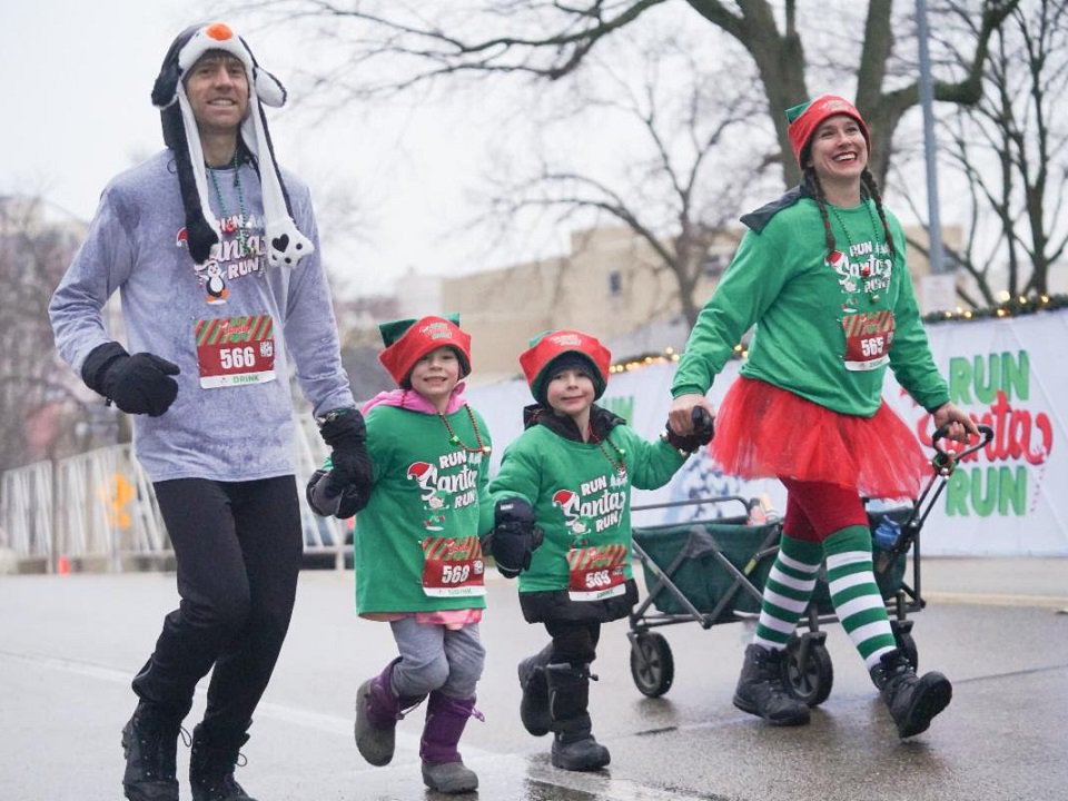 A family of four participating in a past Run Santa Run event.