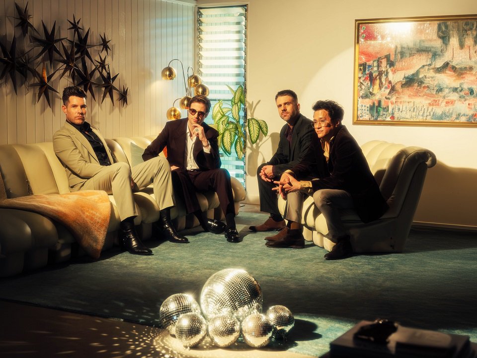 The four members of Saint Motel on a pair of couches.