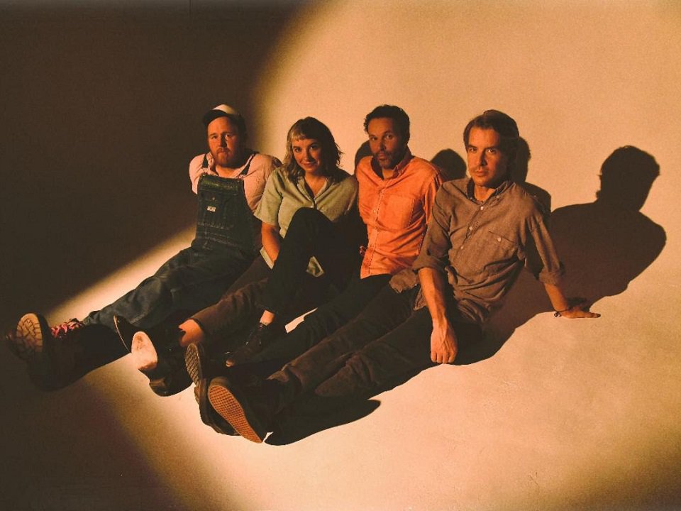 The four members of Blind Pilot sitting on the floor.