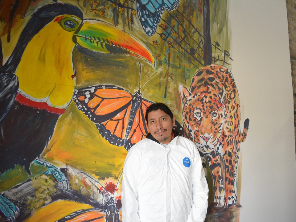 Artist Julio Cachiguango with an in-progress mural at ART House 360.