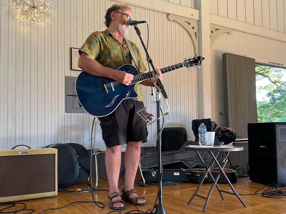 Nick Matthews and guitar on stage.