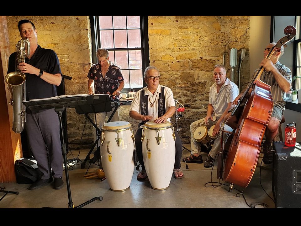 Five members of Tony Castañeda Latin Jazz Band on stage.